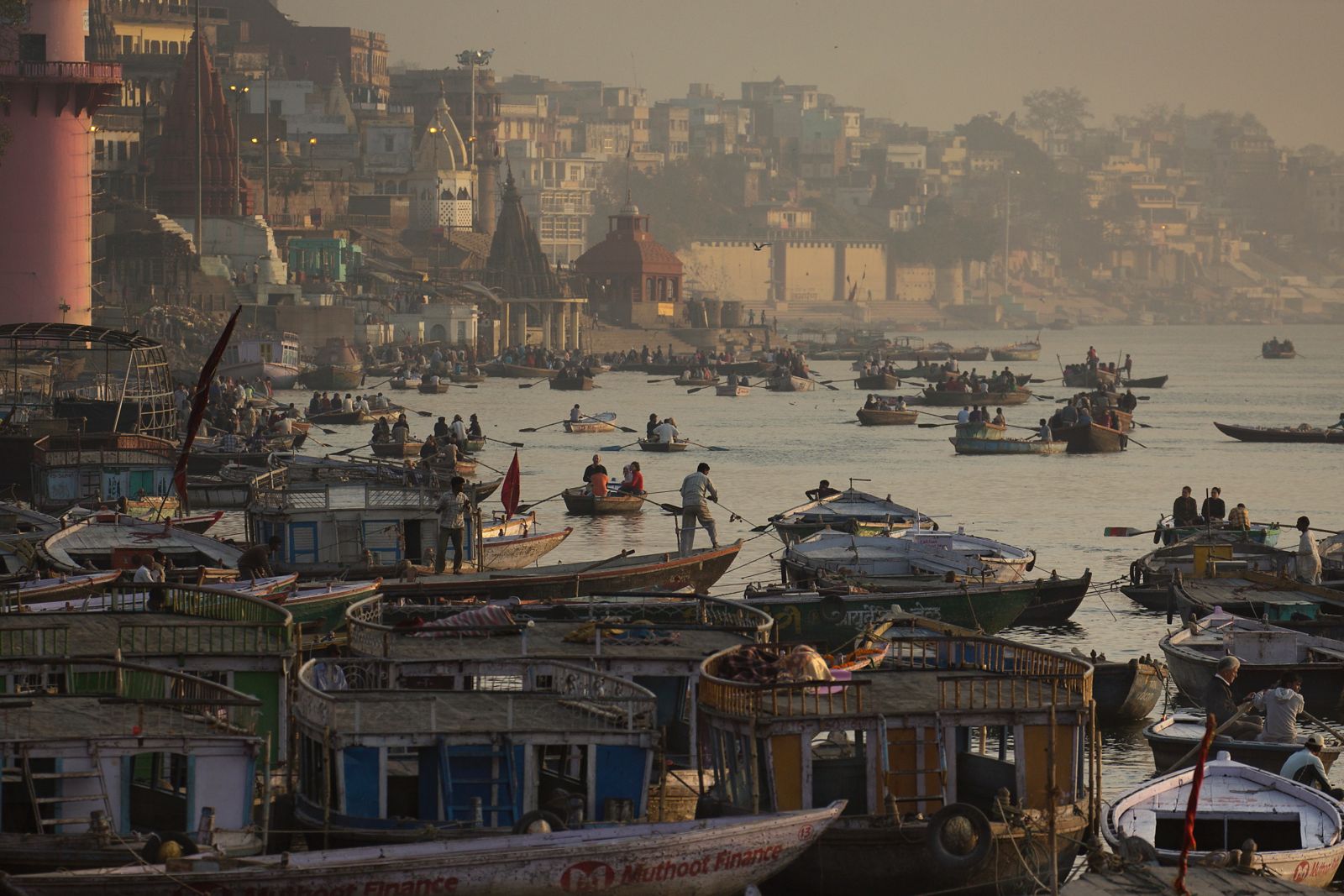 Boats crowding the Ganga below the ghats of Varanasi in morning haze